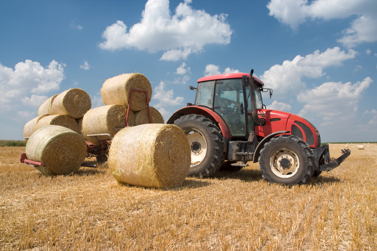 Tractor in field with hay bales