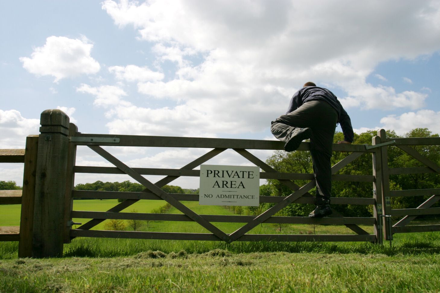 Man climbing over gate